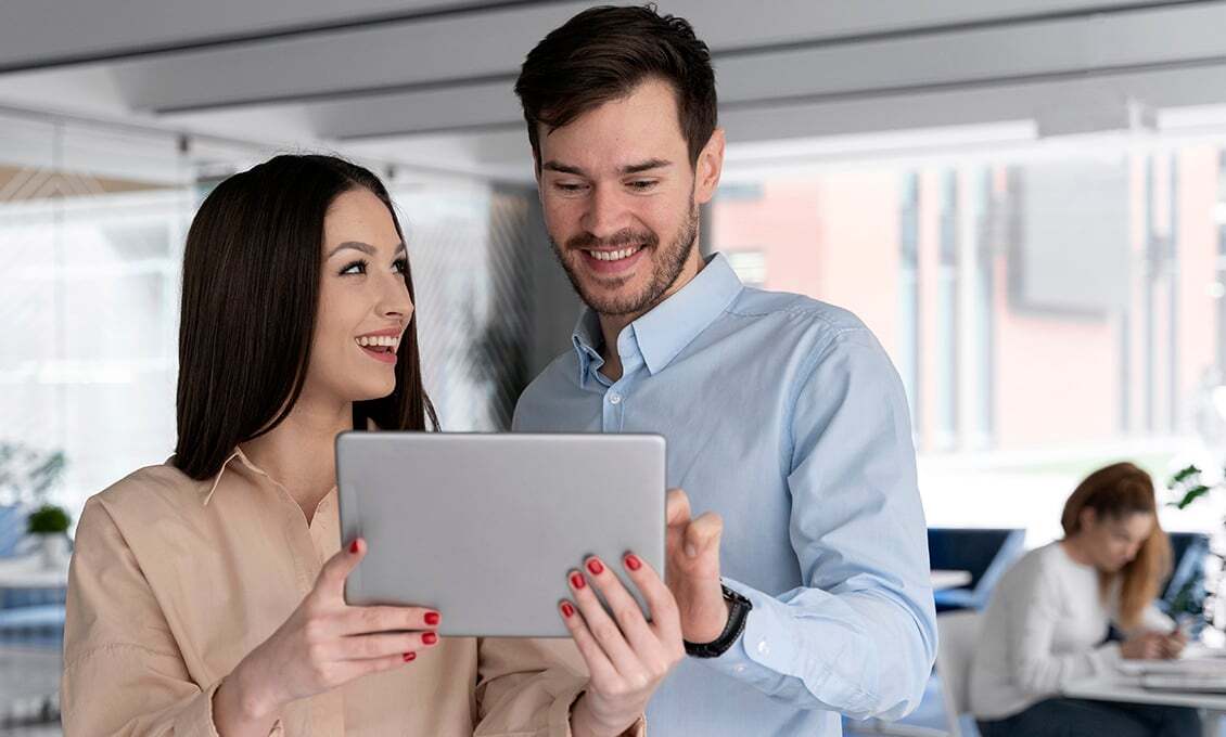Casal de profissionais sorrindo enquanto acompanha o painel do Orbisec em um tablet