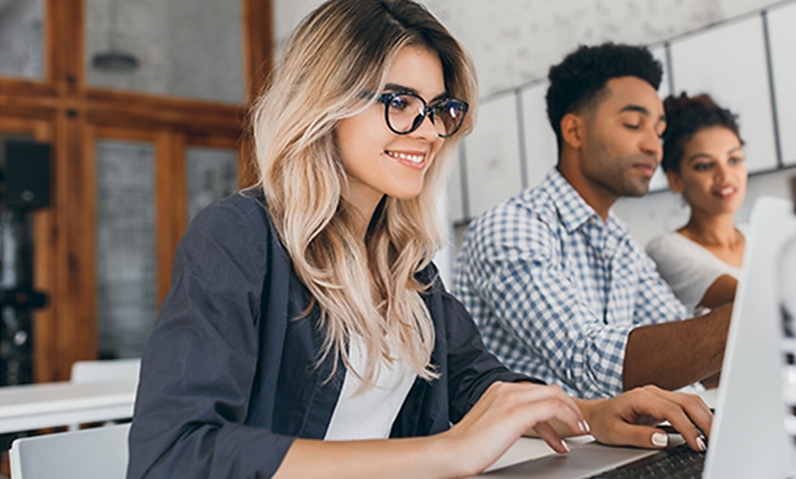Profissionais sorrindo enquanto trabalham juntos em um escritório de tecnologia